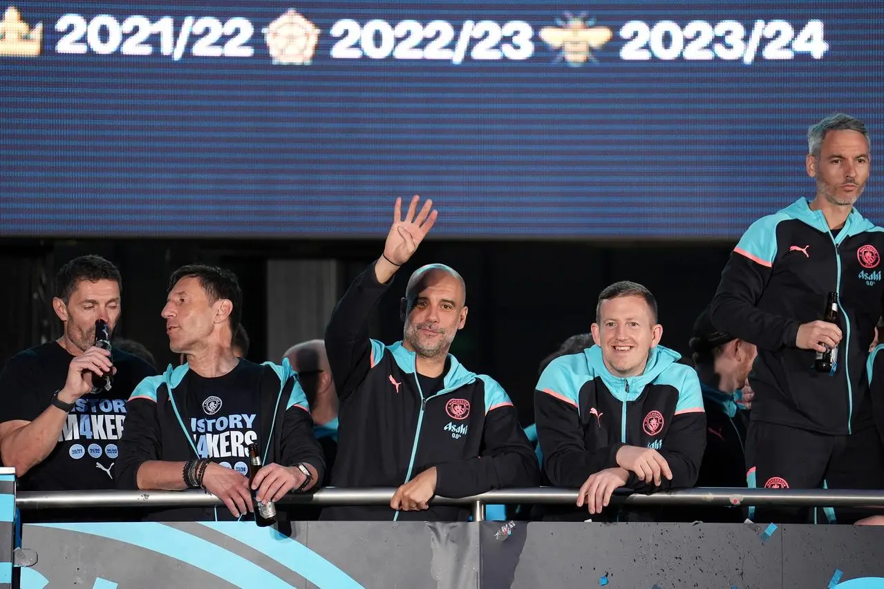 Manchester City manager Pep Guardiola holds up four fingers during last season's Premier League trophy parade