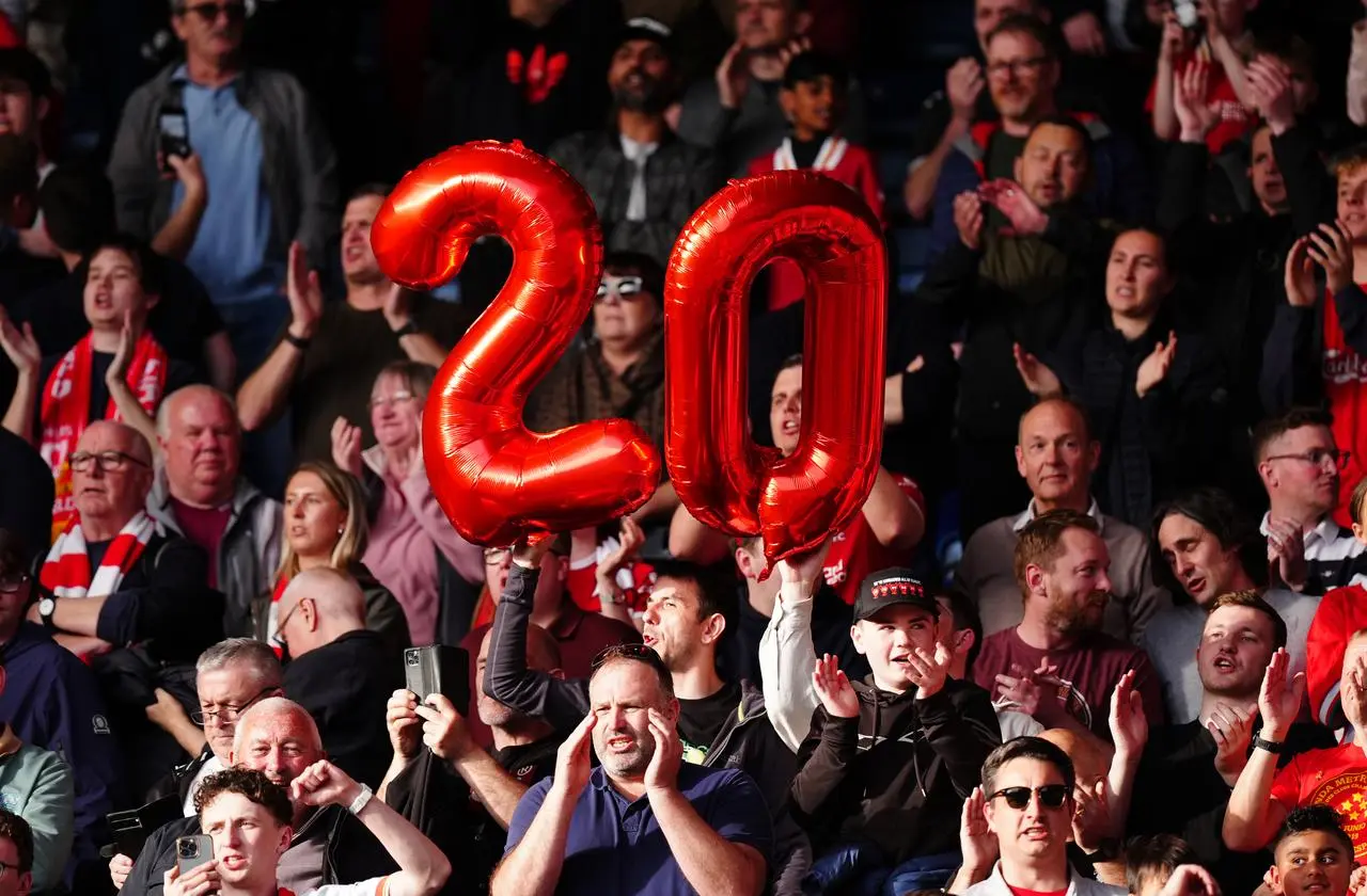 Liverpool fans hold up balloons forming the number 20