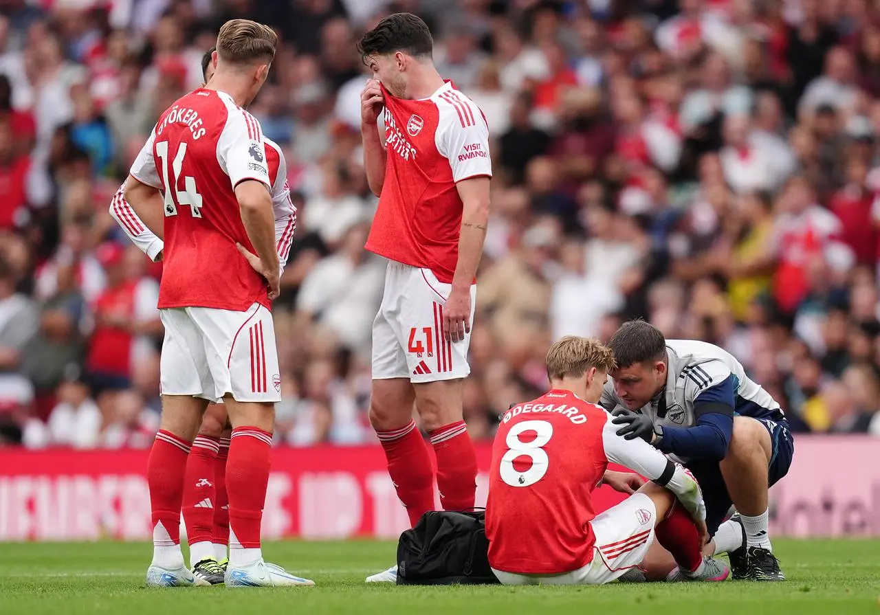Arsenal’s Martin Odegaard is treated by medical staff during the match against Leeds