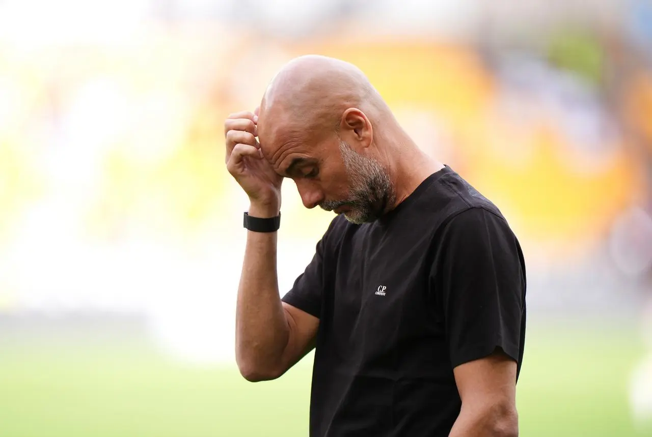 Pep Guardiola in deep thought during Manchester City's game at Wolves
