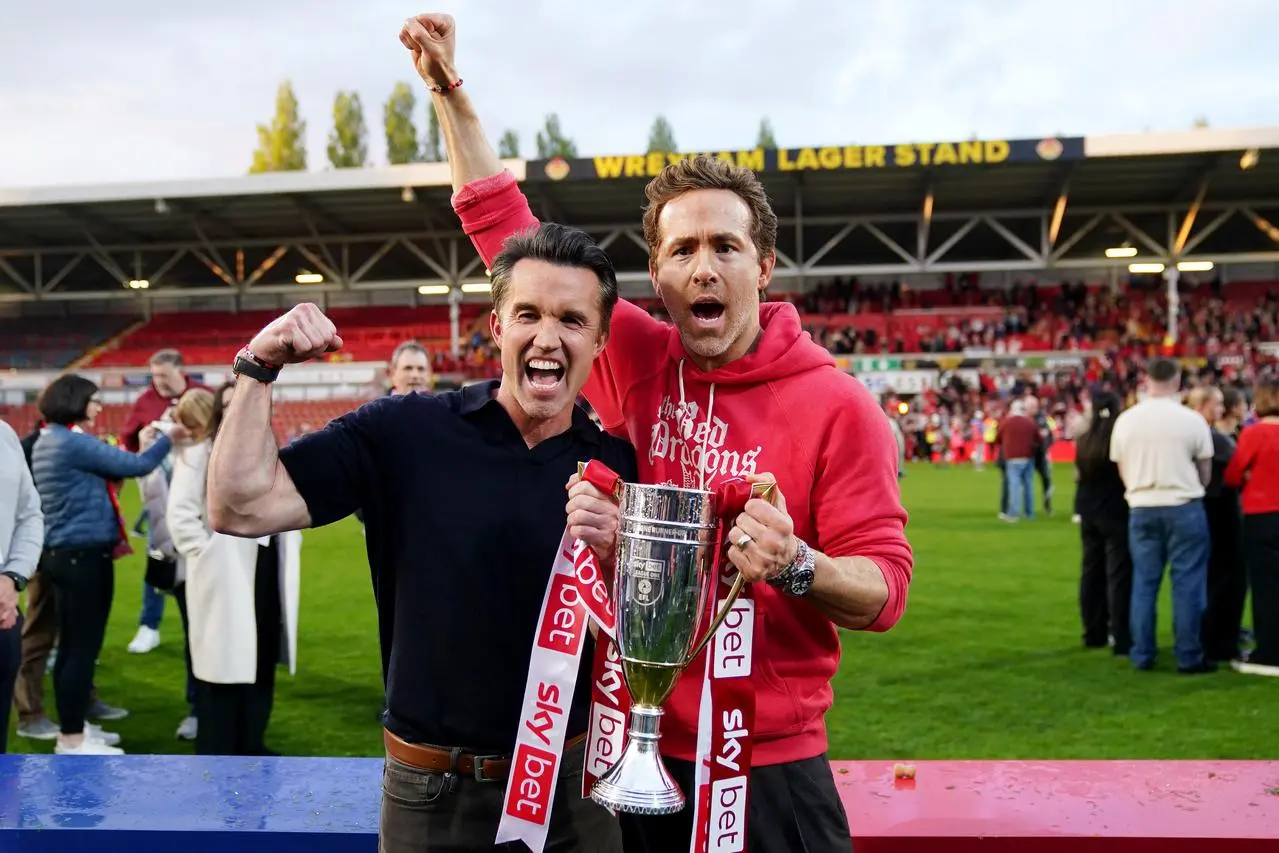 Wrexham co-owners Ryan Reynold, right, and Rob McElhenney. celebrate the club's promotion to the Championship