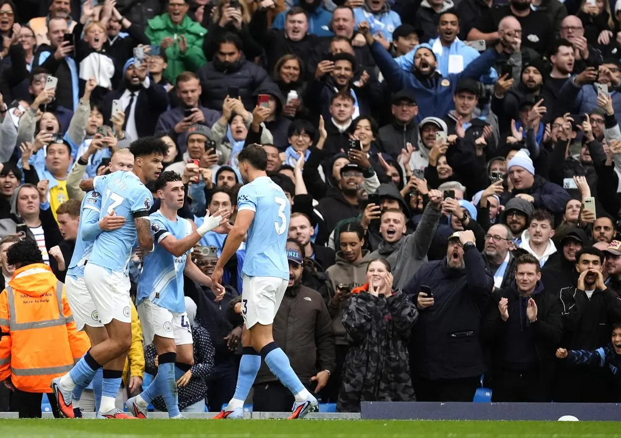 Phil Foden, centre, celebrates scoring Manchester City’s first goal in Sunday's derby