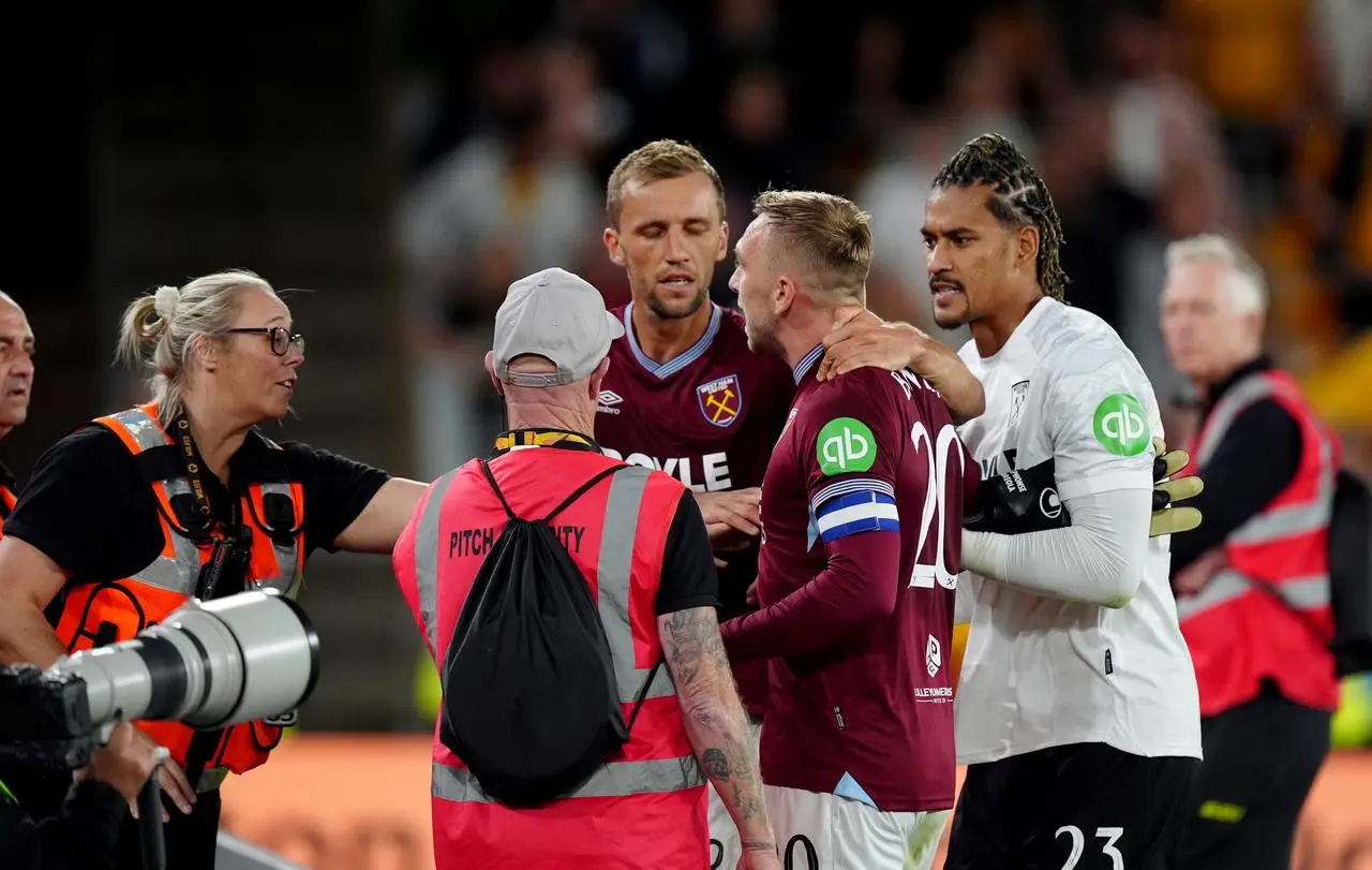 Jarrod Bowen is pulled away from West Ham fans after an argument at Molineux