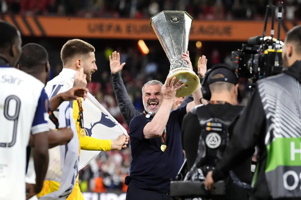Tottenham manager Ange Postecoglou (centre) celebrates with the Europa League trophy