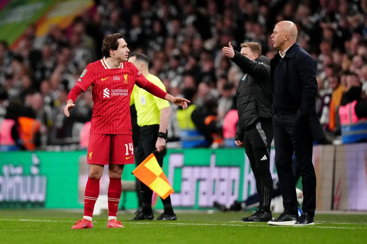 Liverpool forward Federico Chiesa speaks with head coach Arne Slot