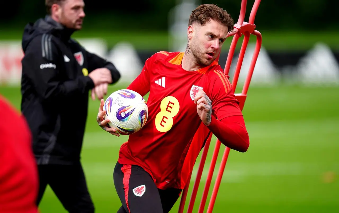 Wales' Joe Rodon carries a ball while running in training