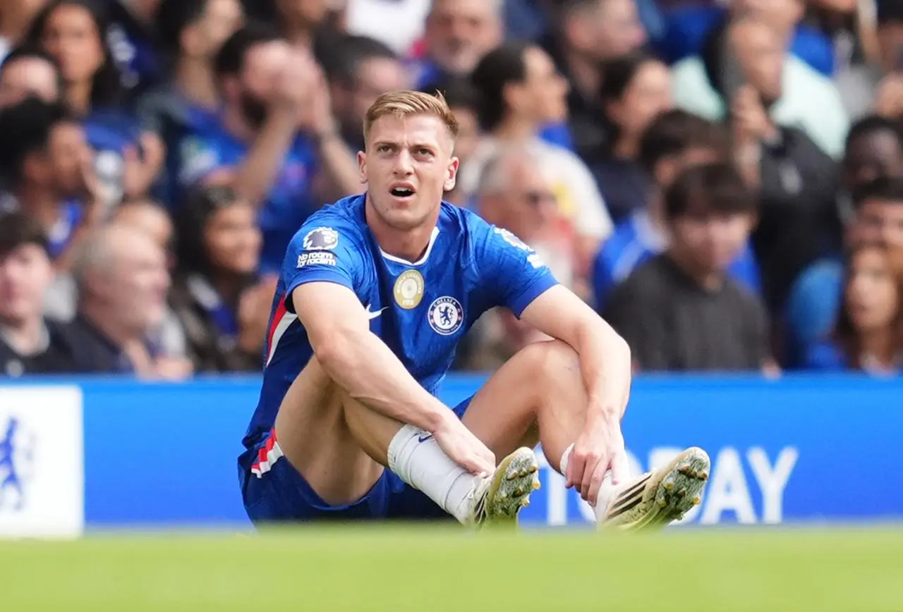 Chelsea’s Liam Delap waits for treatment after pulling up with an injury
