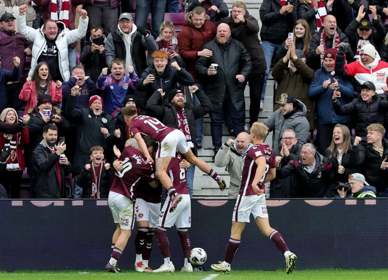 Lawrence Shankland (obscured) is mobbed by his team mates