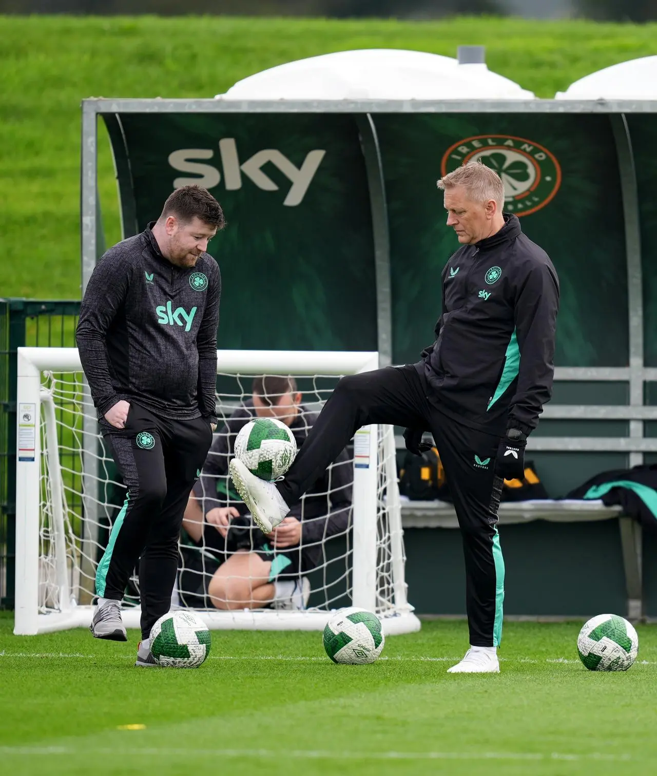 Republic of Ireland manager Heimir Hallgrimsson, right, balances a ball on his foot in training