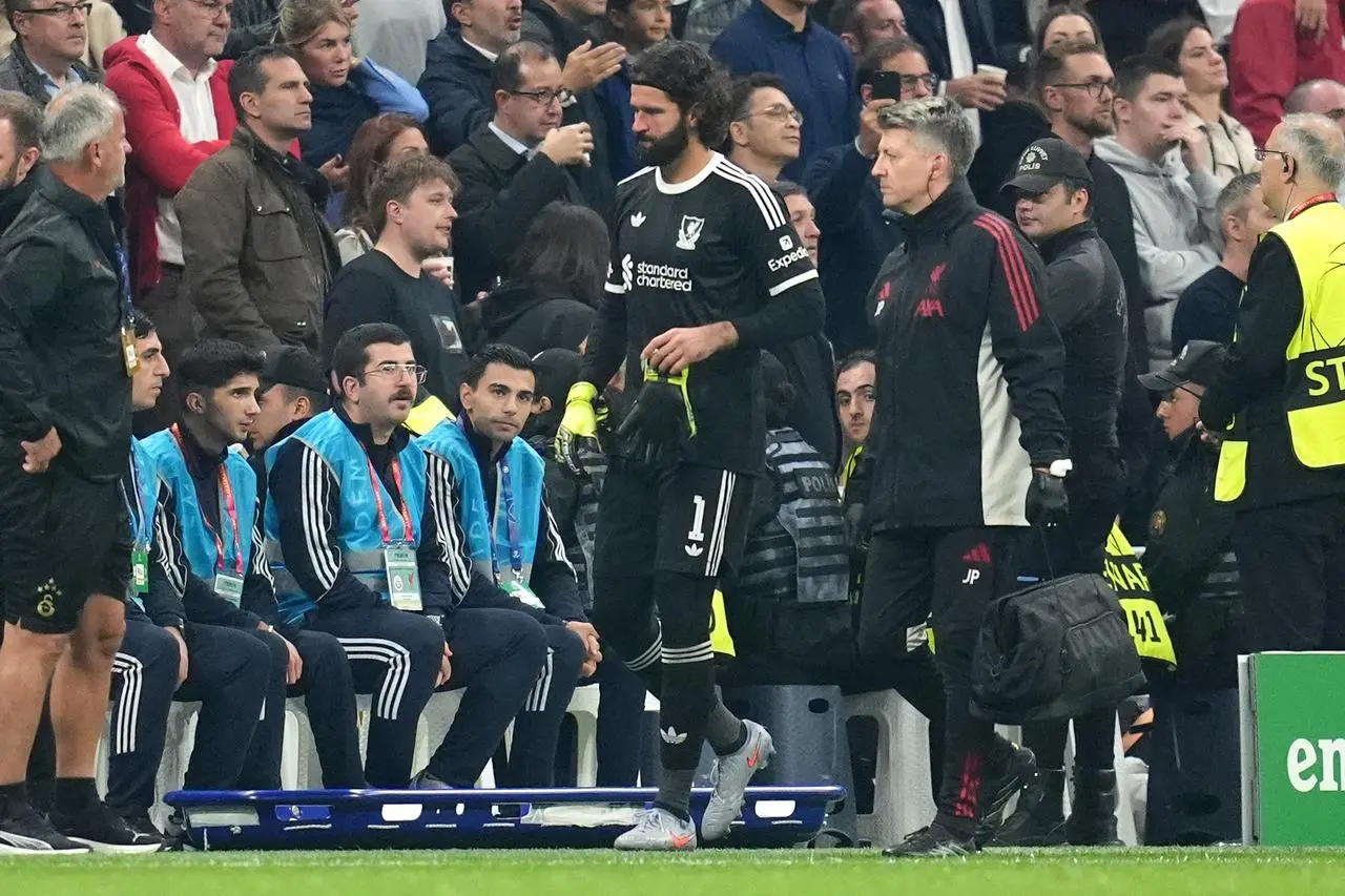 Alison Becker walks with a member of Liverpool's medical staff after being substituted