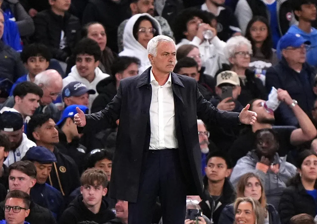 Jose Mourinho stands with his arms outstretched