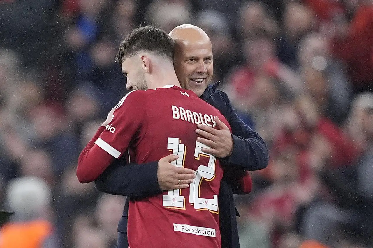 Liverpool manager Arne Slot embraces Conor Bradley after the Champions League win over Real Madrid