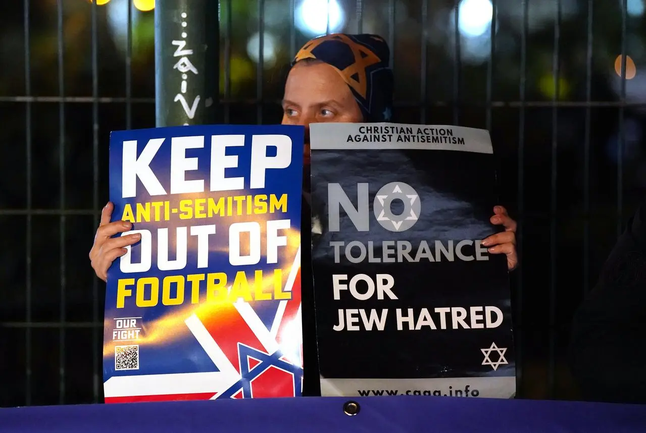 A person holding signs outside Villa Park,