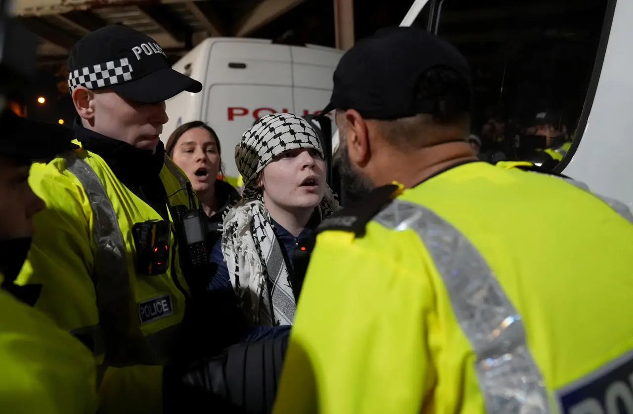 Police officers remove a pro Palestine protester outside Villa Park