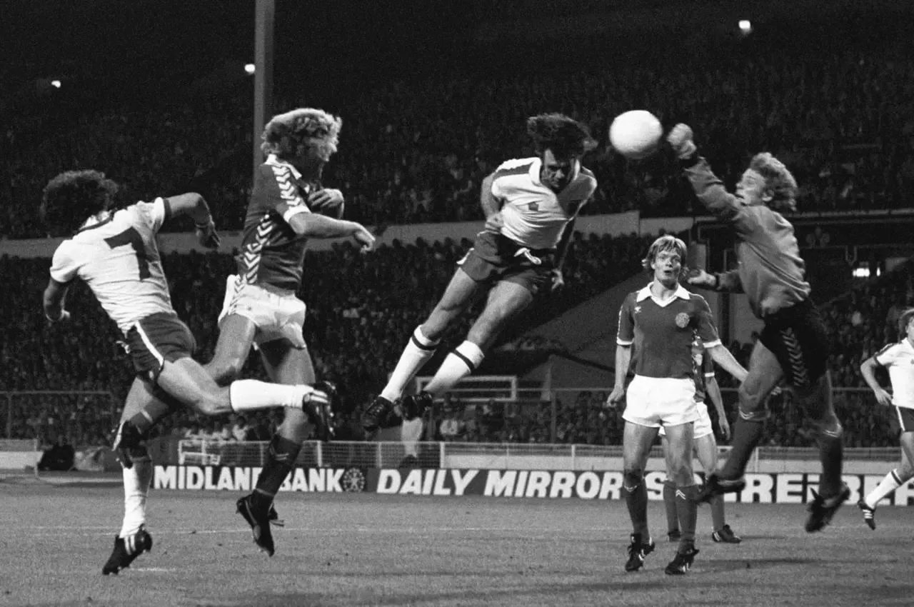 Dave Watson heads the ball towards goal for England in an international against Denmark