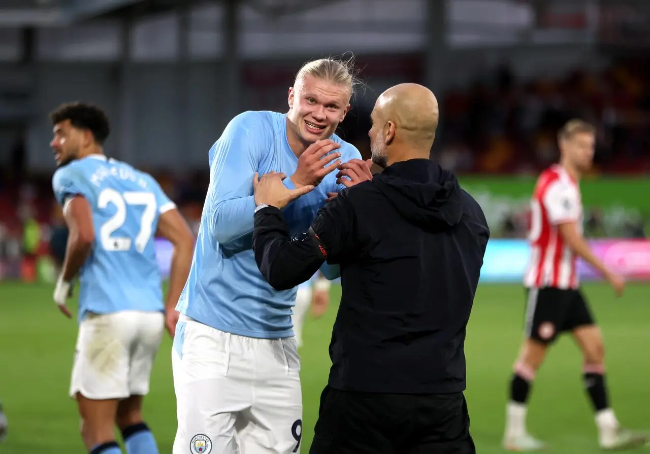 Manchester City’s Erling Haaland, left, shares a joke with manager Pep Guardiola