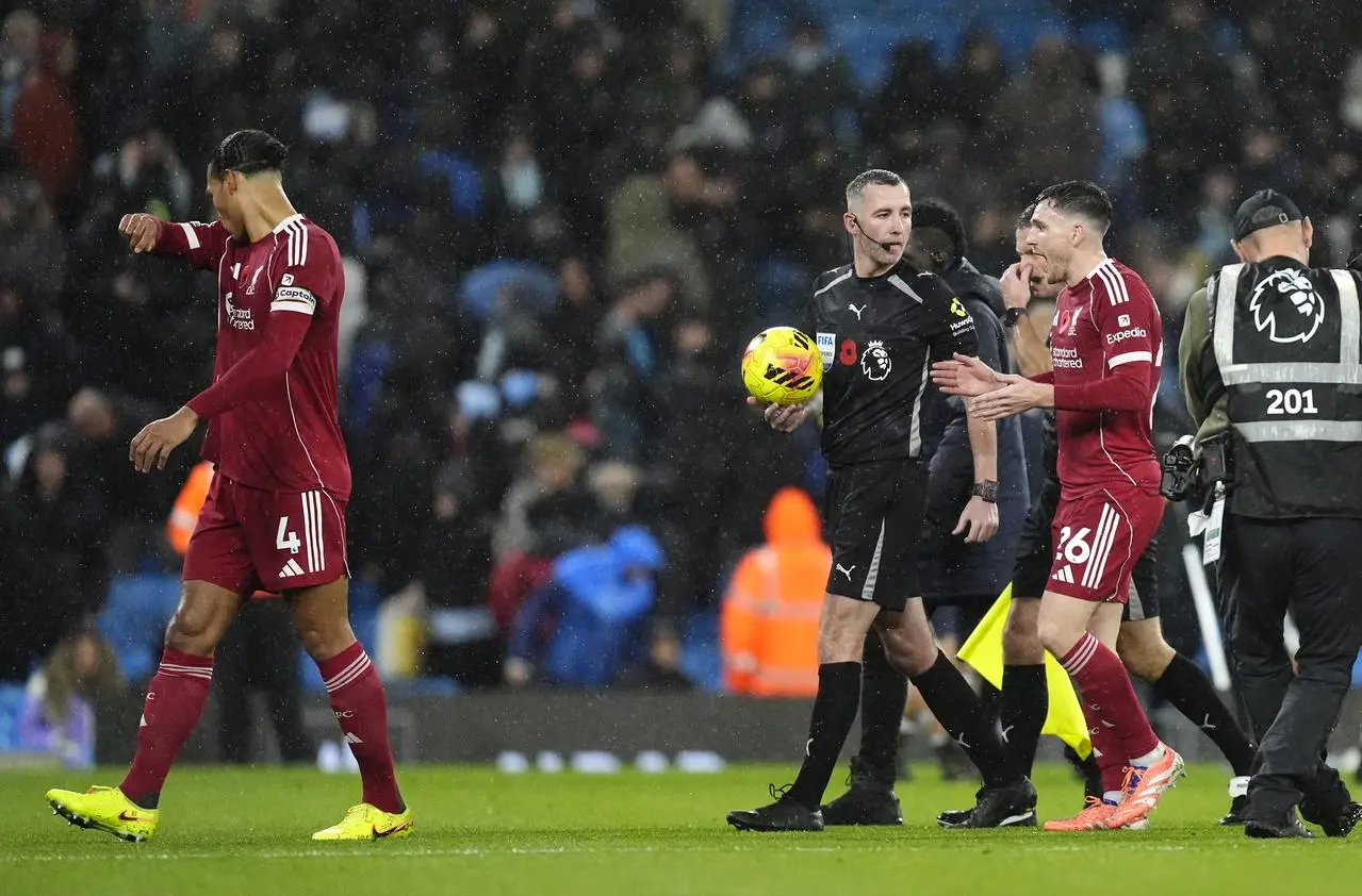 Liverpool’s Andrew Robertson speaks with referee Chris Kavanagh about a decision at Manchester City