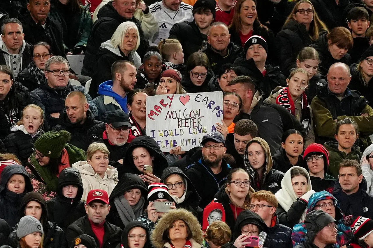 A Manchester United fan holds a sign in support of goalkeeper Mary Earps