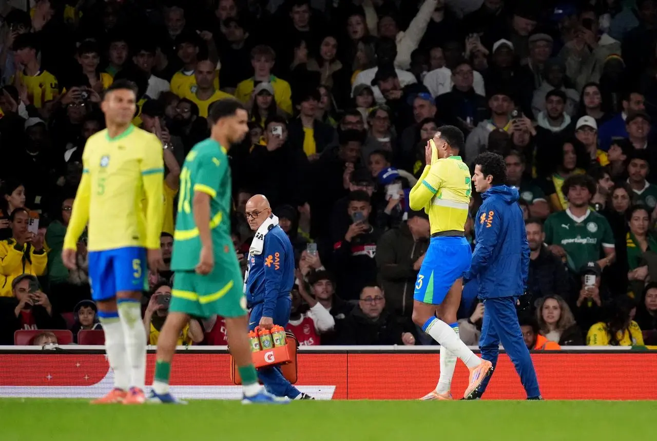 Gabriel Magalhaes, right, walks off the field injured