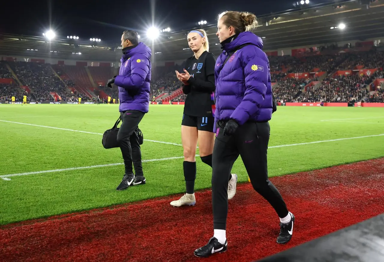 Chloe Kelly (centre) walks off the field with the medical staff
