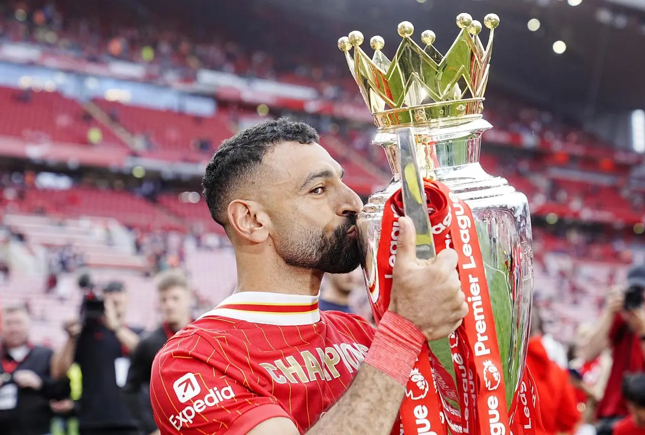 Liverpool’s Mohamed Salah celebrates with the Premier League trophy