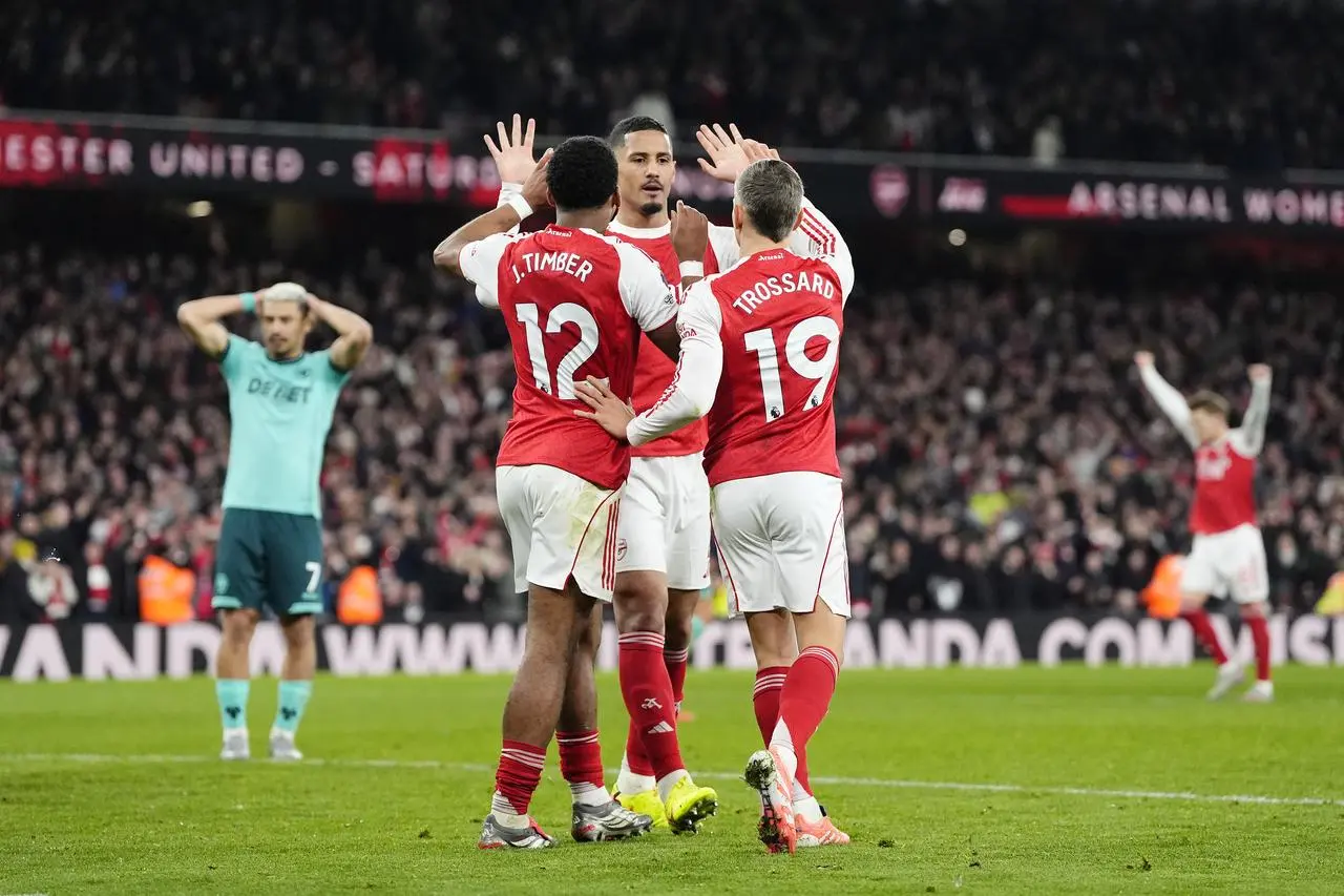 Arsenal’s William Saliba (centre) celebrates with Jurrien Timber and Leandro Trossard (right) after a goal against Wolves