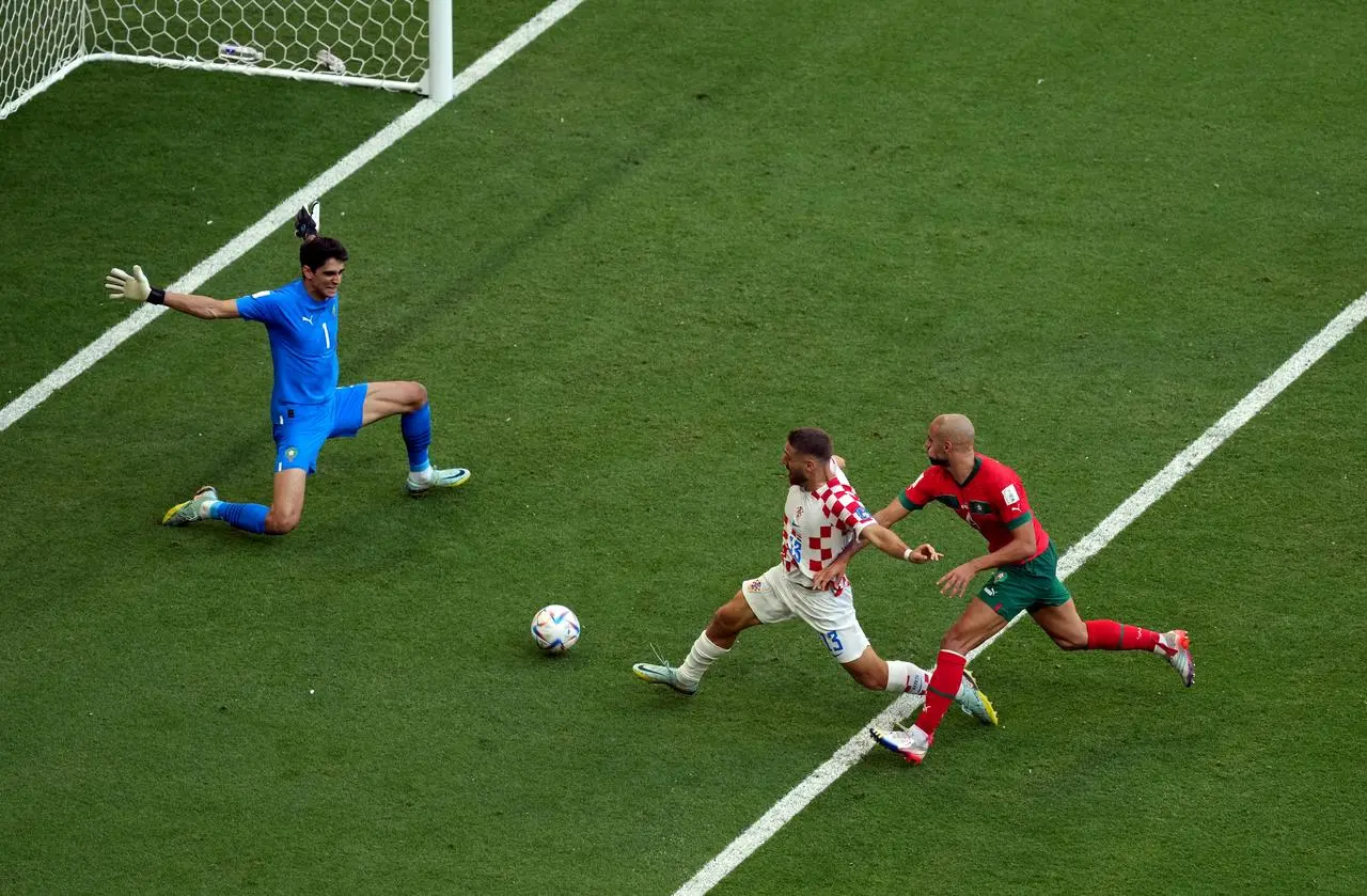 Morocco goalkeeper Yassine Bounou saves from Nikola Vlasic