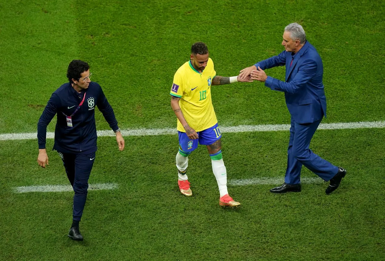 Brazil boss Tite (right) consoles Neymar as the forward comes off (Mike Egerton/PA).