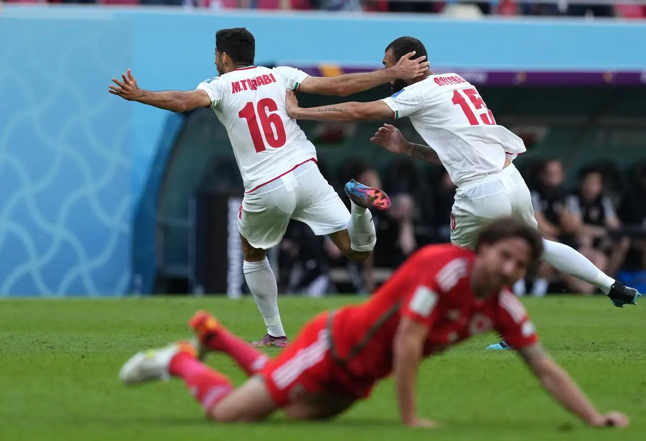 Roozbeh Cheshmi, right, celebrates his goal in added time 