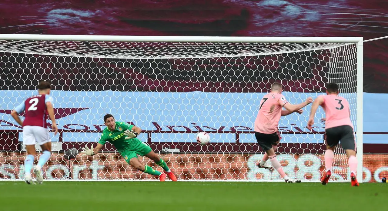 Aston Villa’s Emiliano Martinez saves a penalty from Sheffield United’s John Lundstram, second right