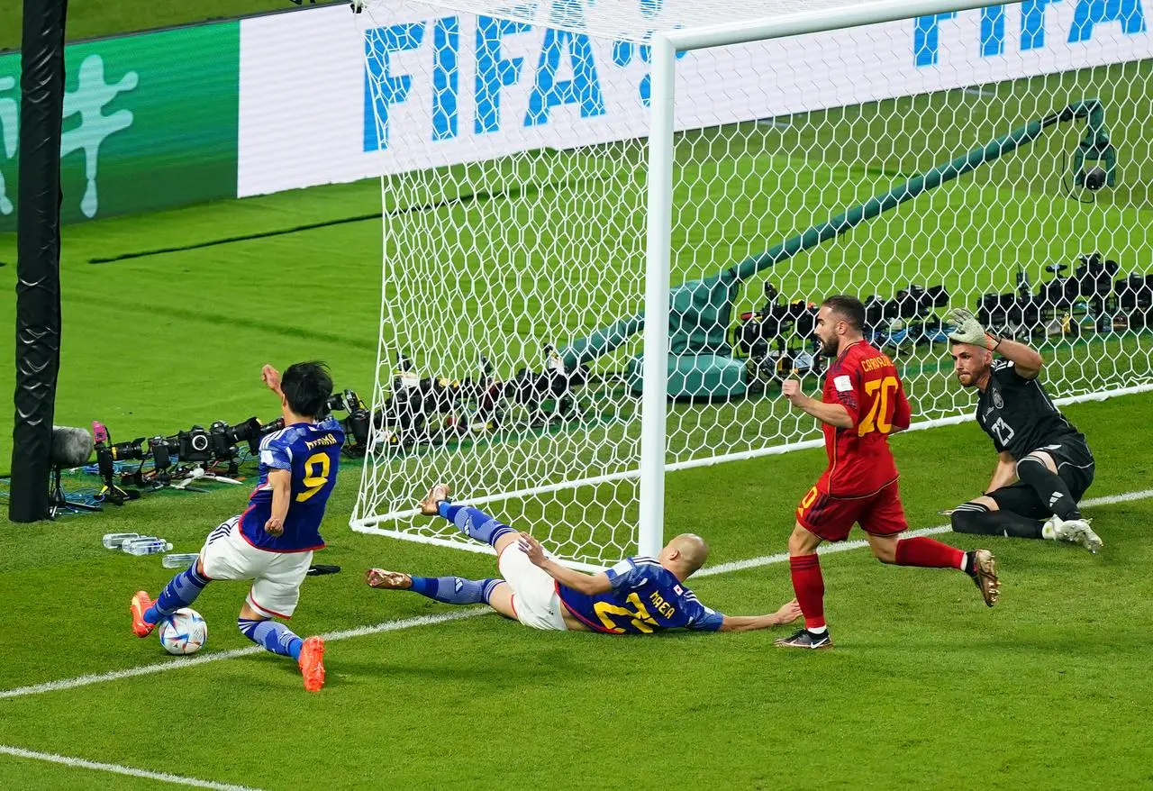 Japan’s Kaoru Mitoma (left) crosses the ball