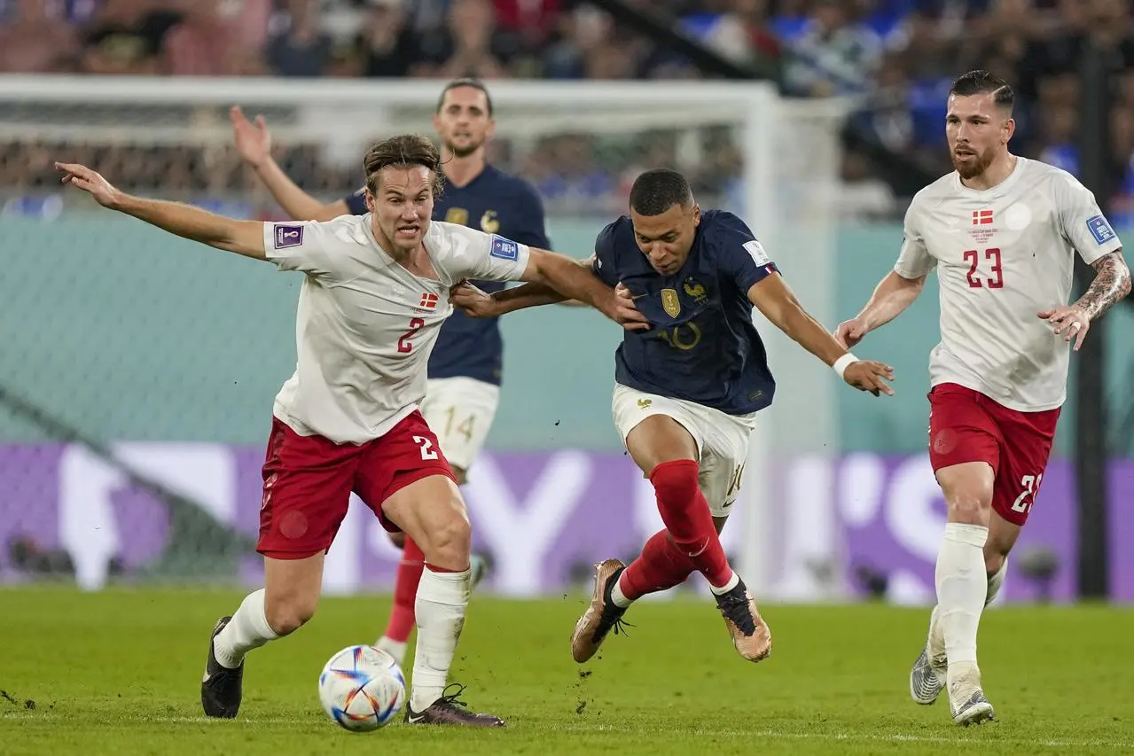 Kylian Mbappe, centre, runs at the Denmark defence in the group stage