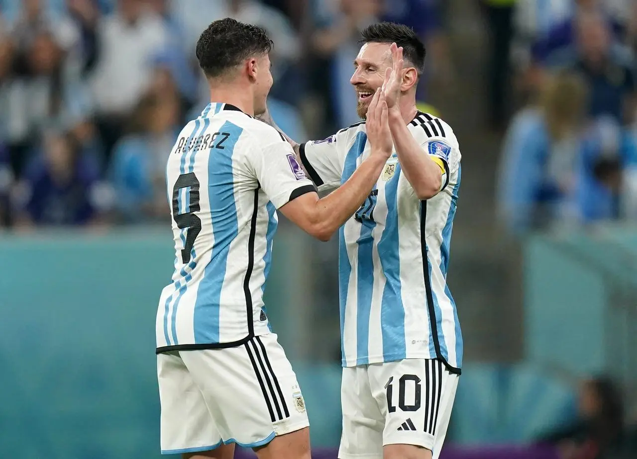 Lionel Messi congratulates Julian Alvarez, left, after Argentina's third goal