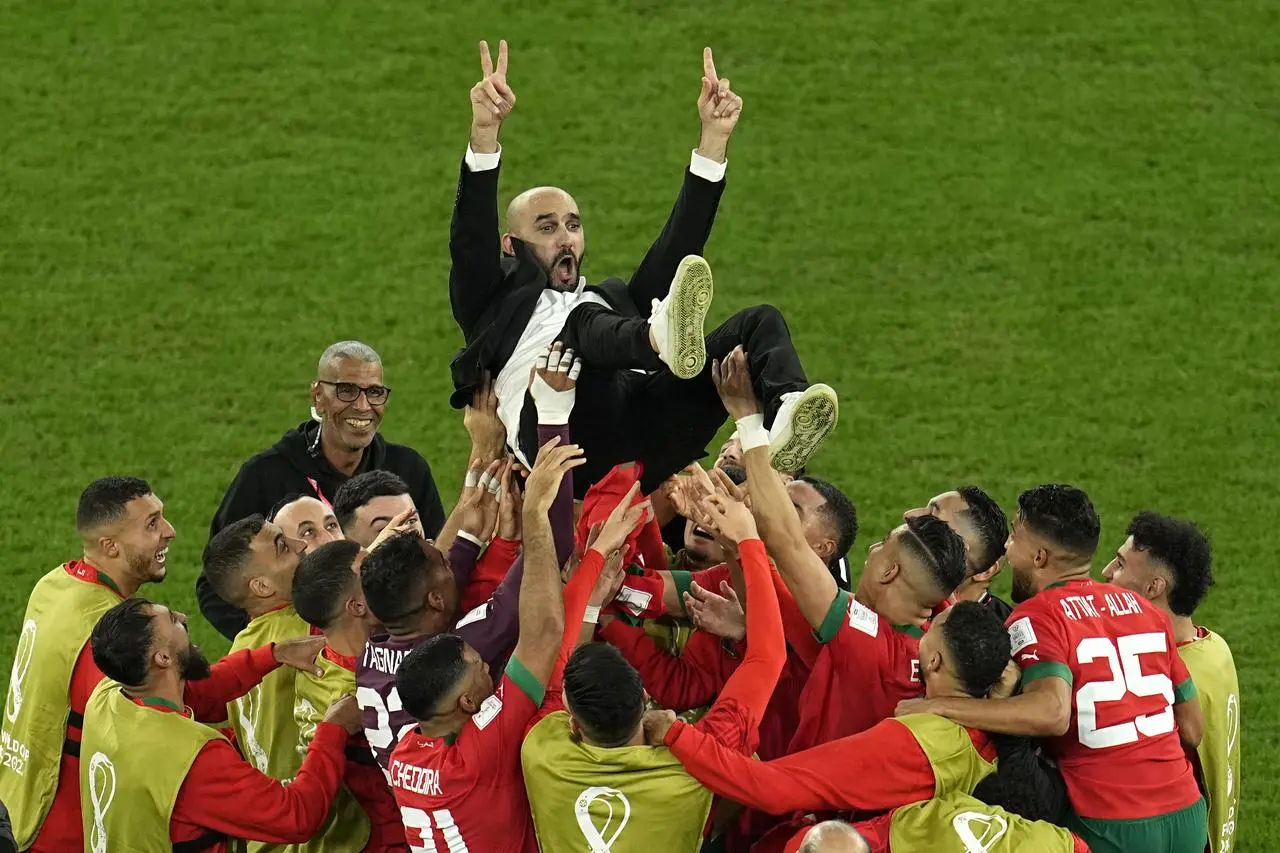 Morocco’s coach Walid Regragui is thrown in the air by his players