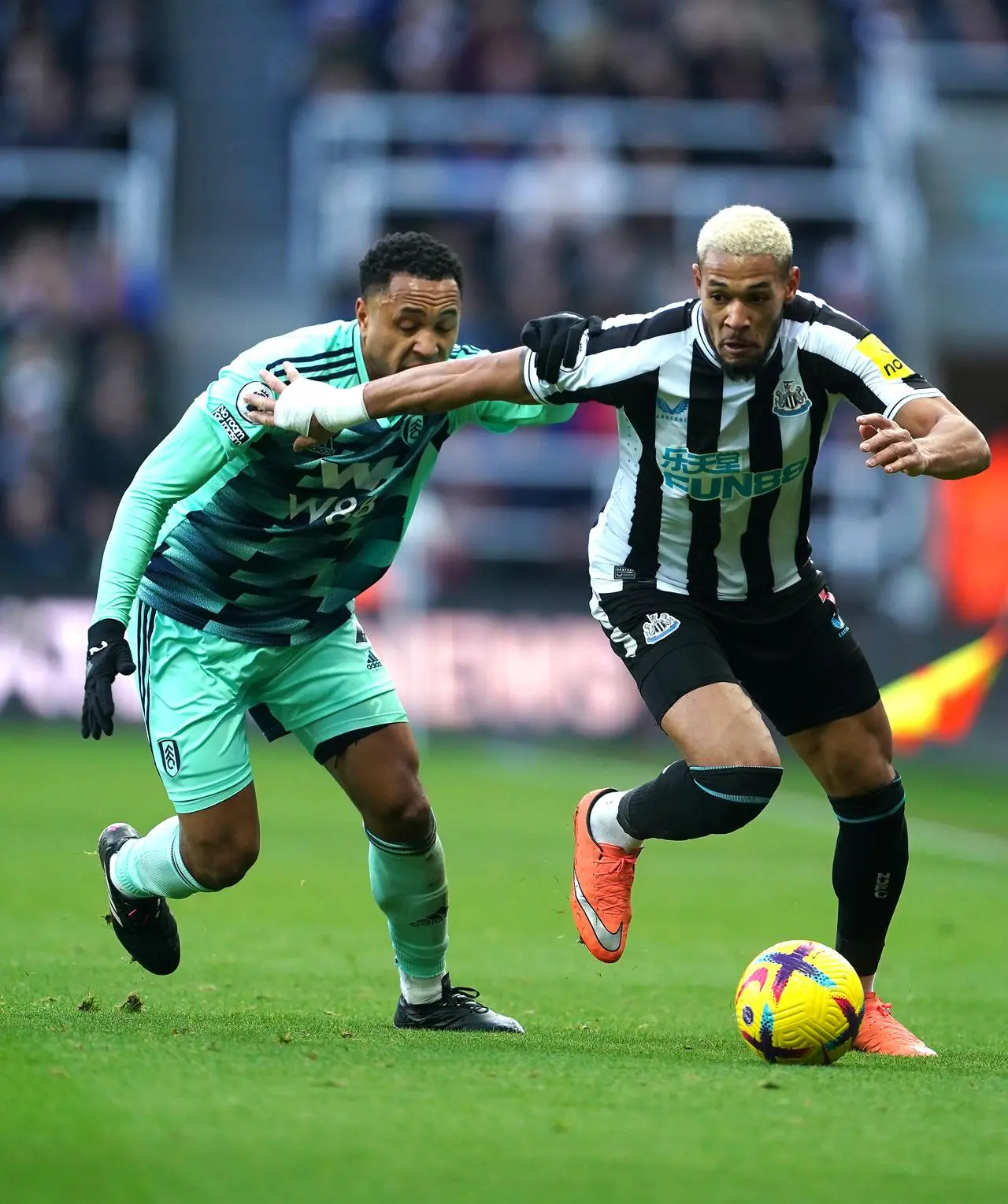 Joelinton, right, takes on Fulham's Kenny Tete