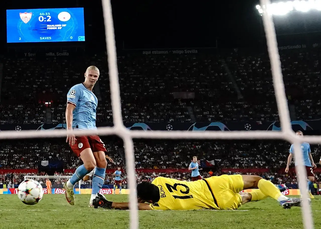 Erling Haaland, left, scores his second goal against Sevilla