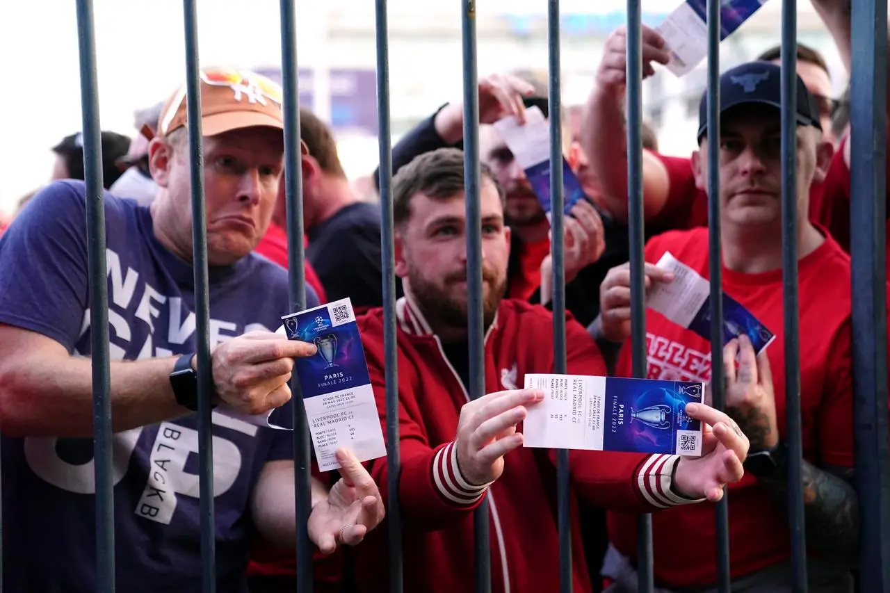 Liverpool fans stuck outside the ground show their match tickets