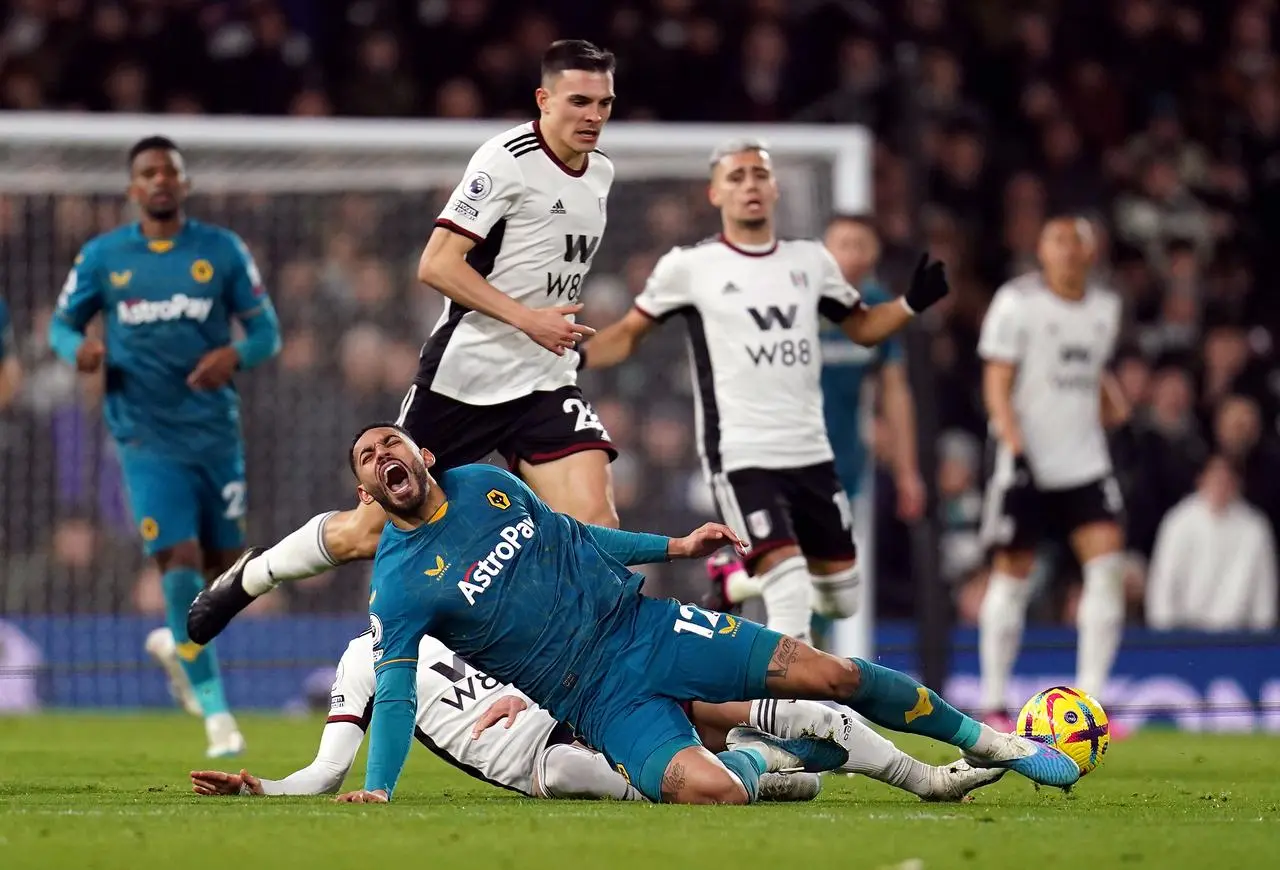 Matheus Cunha goes down in pain after a tackle by Fulham’s Sasa Lukic, hidden