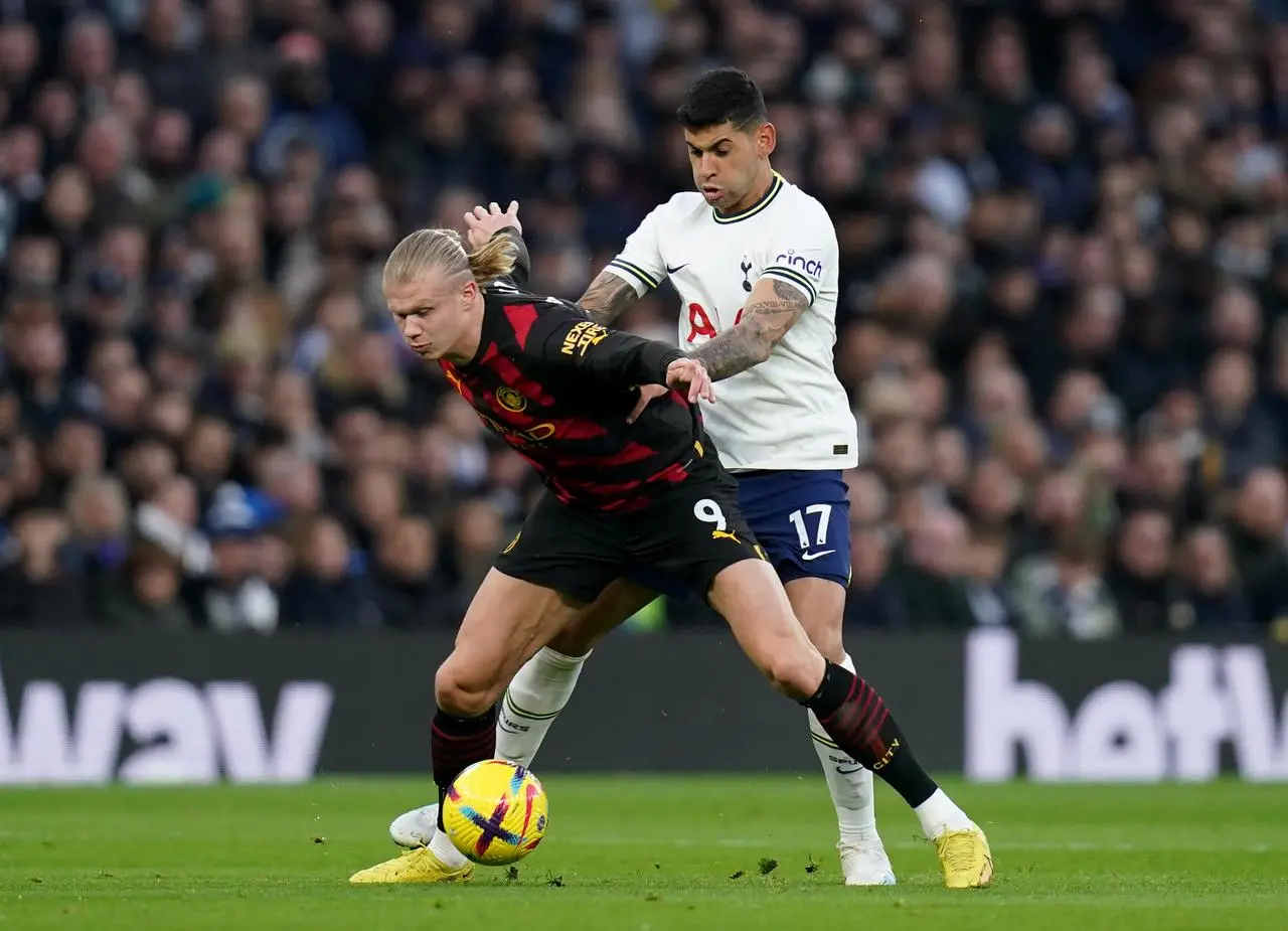 Erling Haaland (left) and Cristian Romero battle for the ball