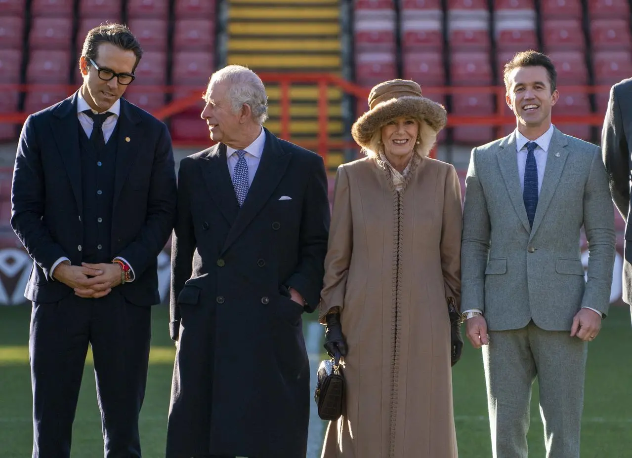 King Charles III and the Queen Consort meet Ryan Reynolds (left) and Rob McElhenney (right) during a visit to Wrexham's Racecourse Ground