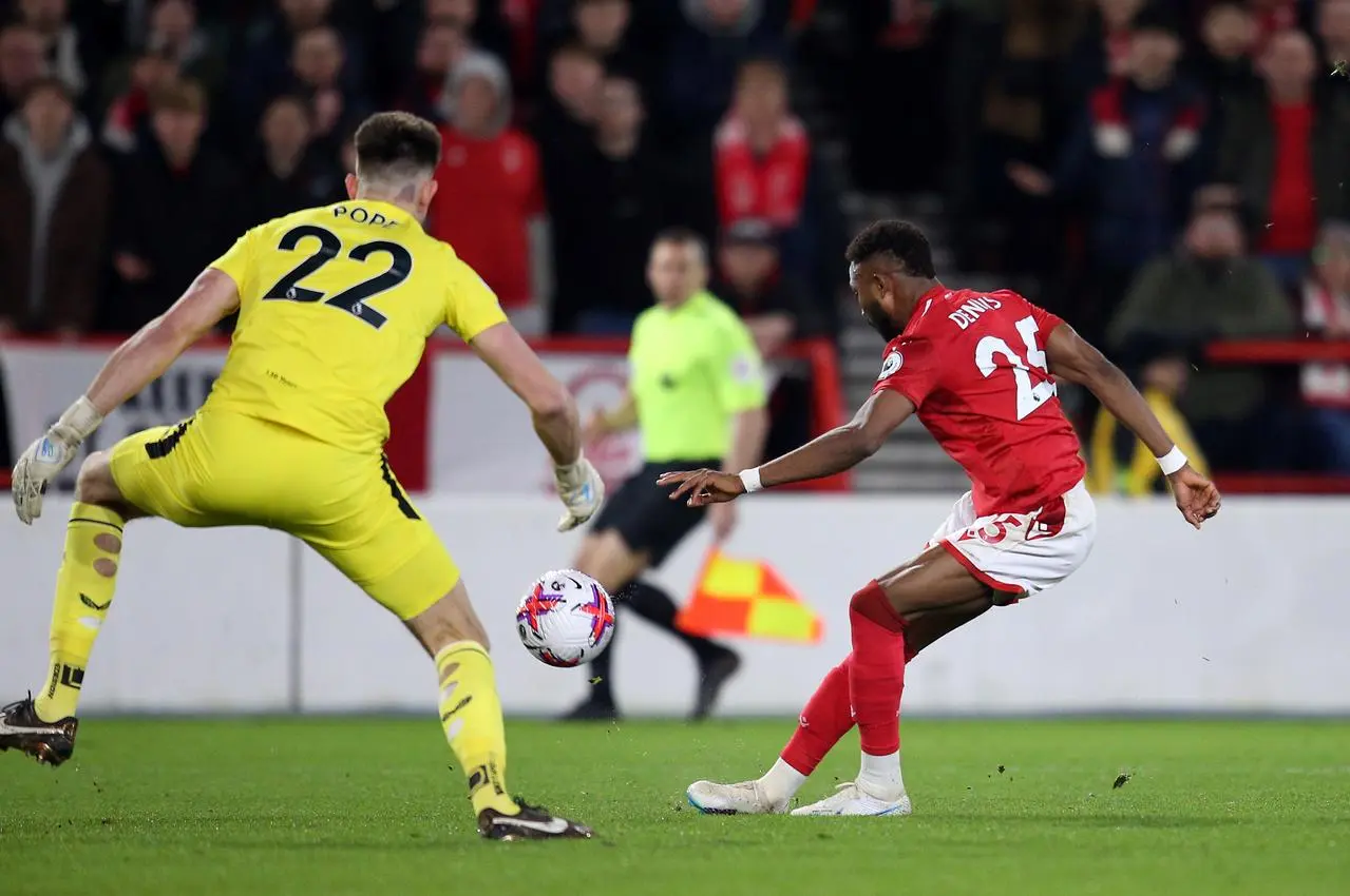 Emmanuel Dennis chips Nick Pope, left, to put Nottingham Forest in front