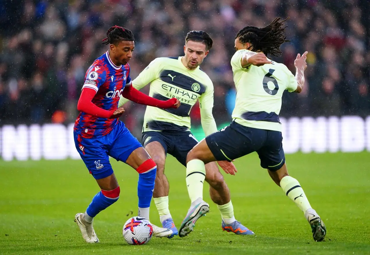 Crystal Palace’s Michael Olise, left, battles for the ball with Manchester City’s Jack Grealish and Nathan Ake 