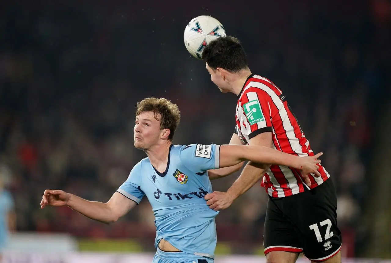 John Egan, right, clears the ball during the FA Cup fourth round replay against Wrexham