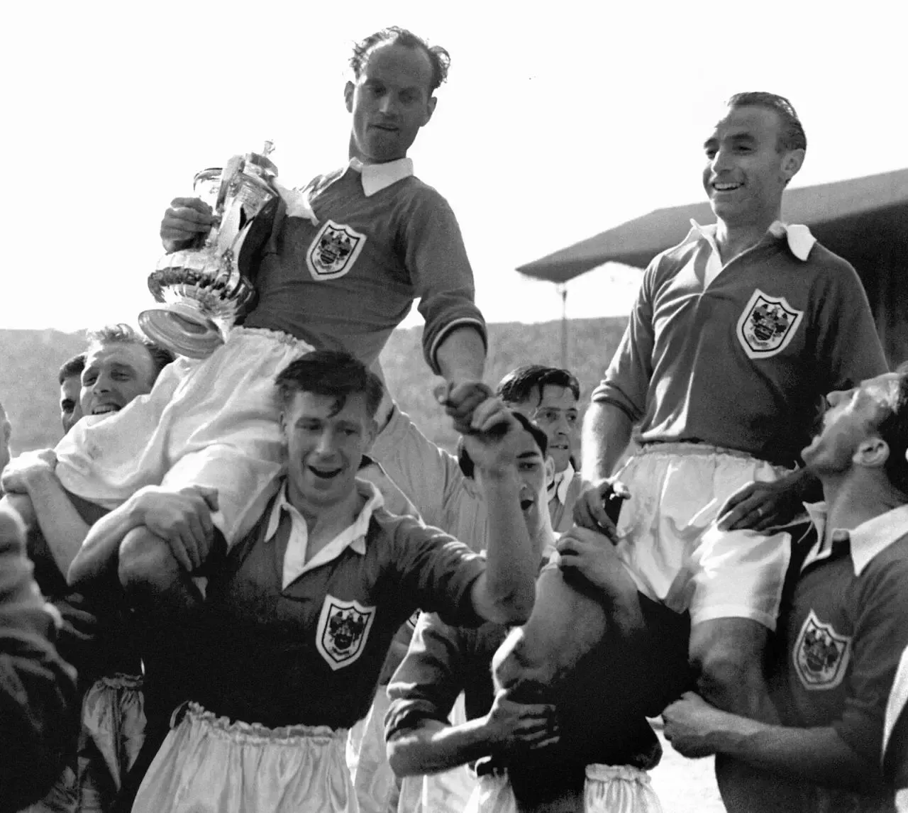 Stanley Matthews (right) is chaired from the Wembley pitch with Blackpool captain Harry Johnson holding the FA Cup