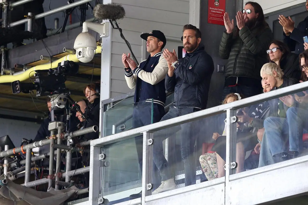 Wrexham's owners Rob McElhenney, left, and Ryan Reynolds applaud the teams out on to the pitch