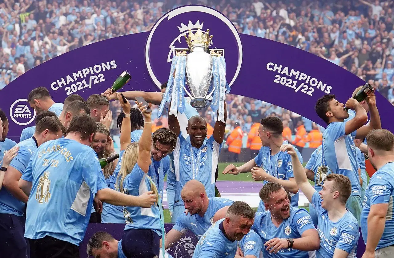 Fernandinho, centre, lifts the trophy as Manchester City celebrate last season's title win