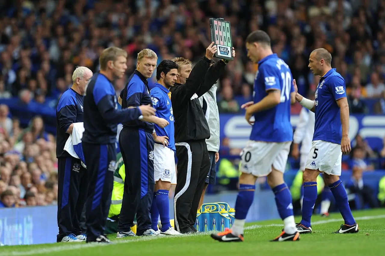 Mikel Arteta (centre) waits to come on as a substitute