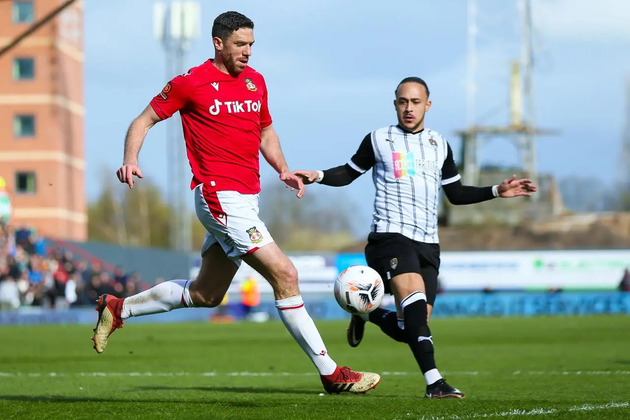 Wrexham's Ben Tozer, left, shields the ball from Notts County’s Jodi Jones