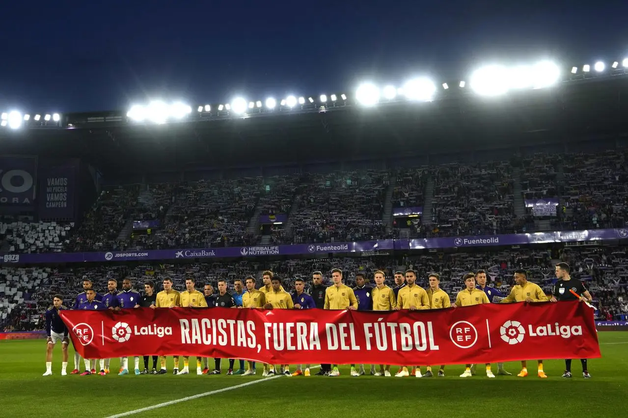 Players show a banner reading, in Spanish, ‘Racism, out of football’ before the match between Valladolid and Barcelona 