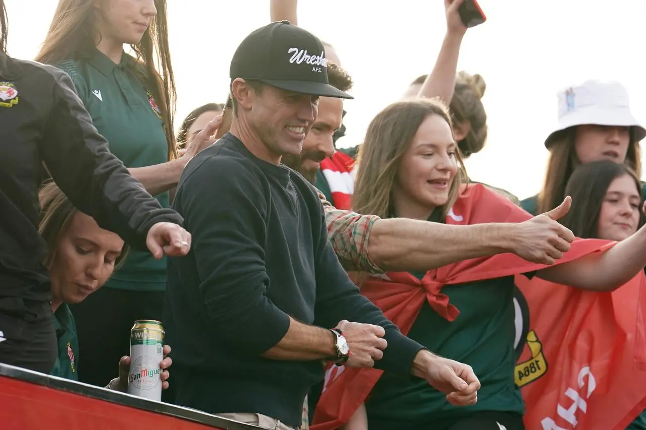 Wrexham owners Rob McElhenney and Ryan Reynolds (behind) celebrate during the victory parade